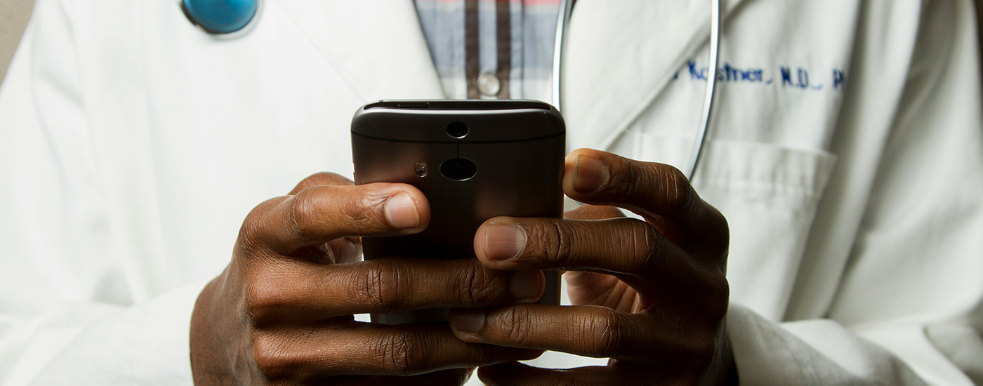 A doctor's hands holding a mobile phone
