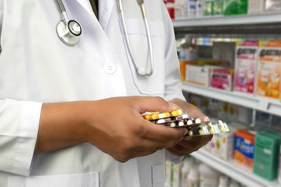 Pharmacist hold several foil packets containing prescription drugs