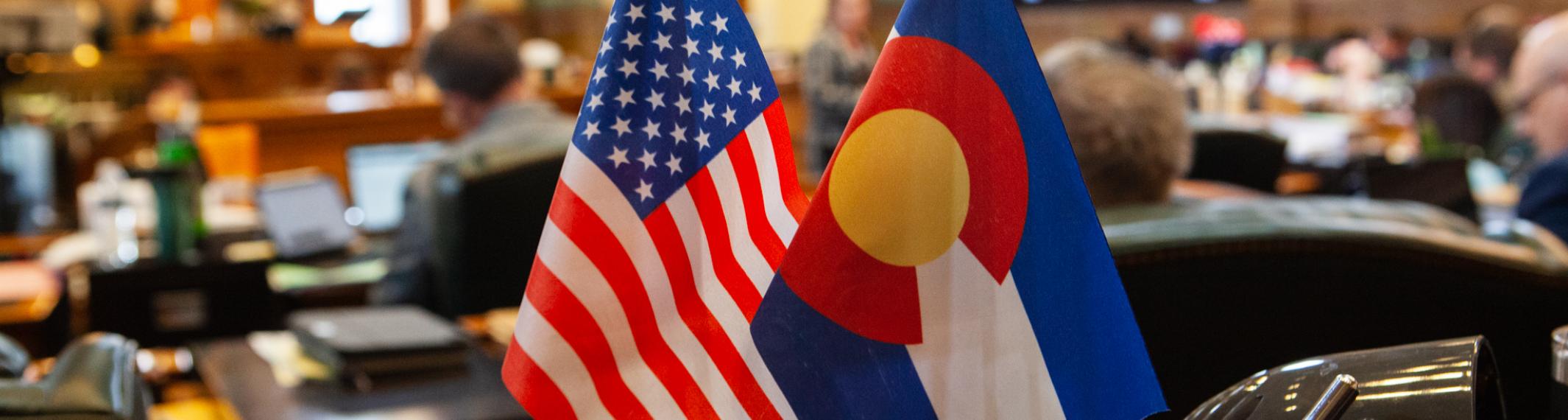 Flags on a desk in the Colorado House of Representatives chamber