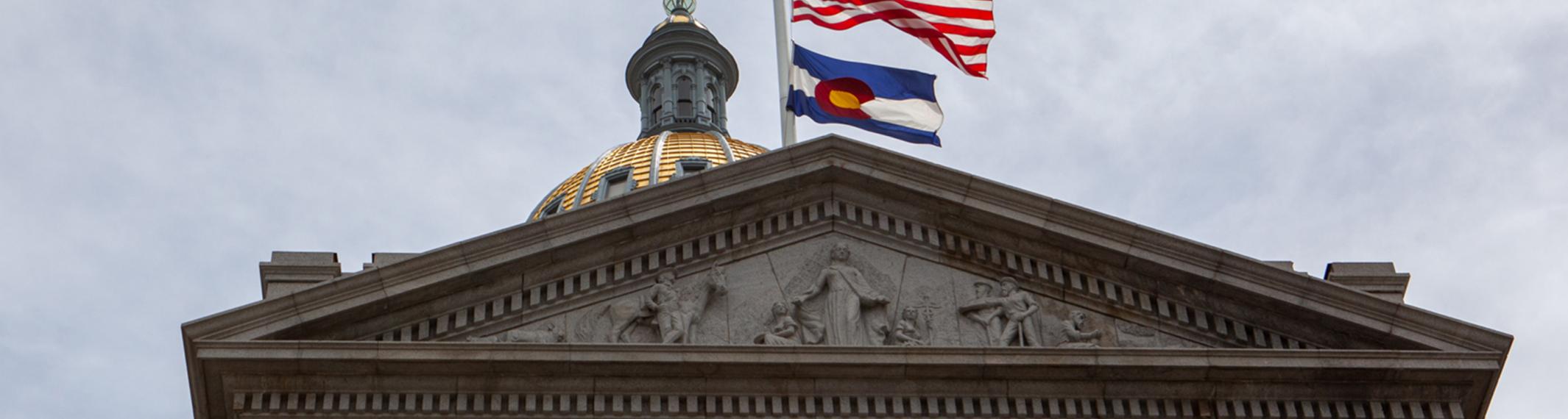 Front of the Colorado State Capitol with U.S. and Colorado flags blowing in the wind
