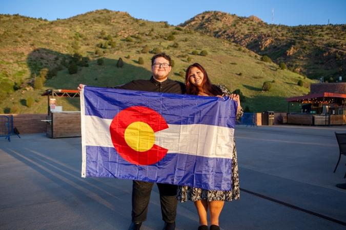 Two Coloradans hold up the state flag