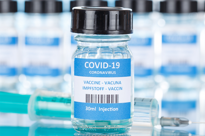 A small glass jar labelled as vaccine for COVID-19