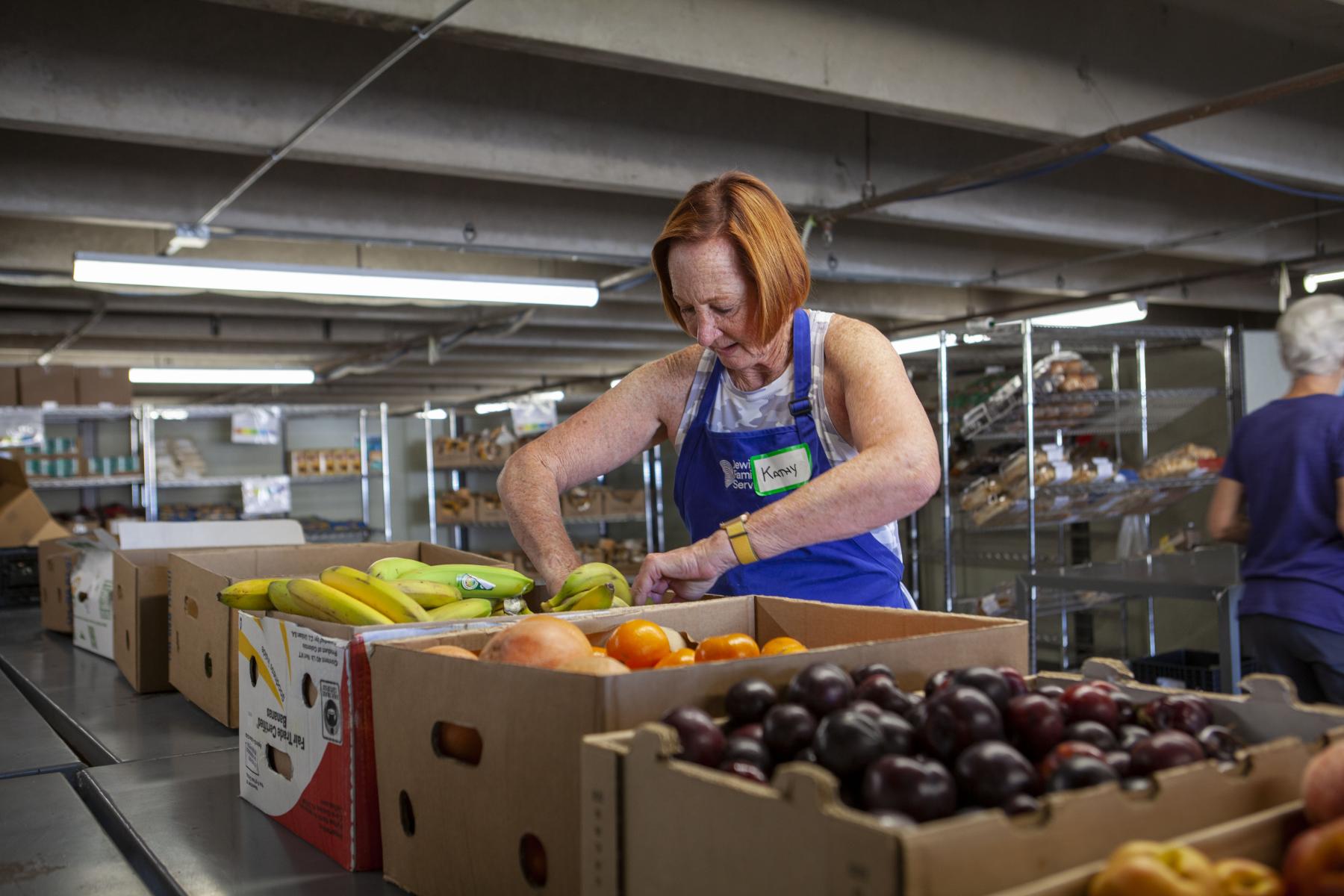 Volunteer Kathy Sabine prepares boxes of food at the Harry and Jeanette Weinberg Food Pantry in Denver.