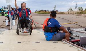 Alison Rehfus greets coach Gilbert Vasquez on her way to the Team Blue dragon boat.