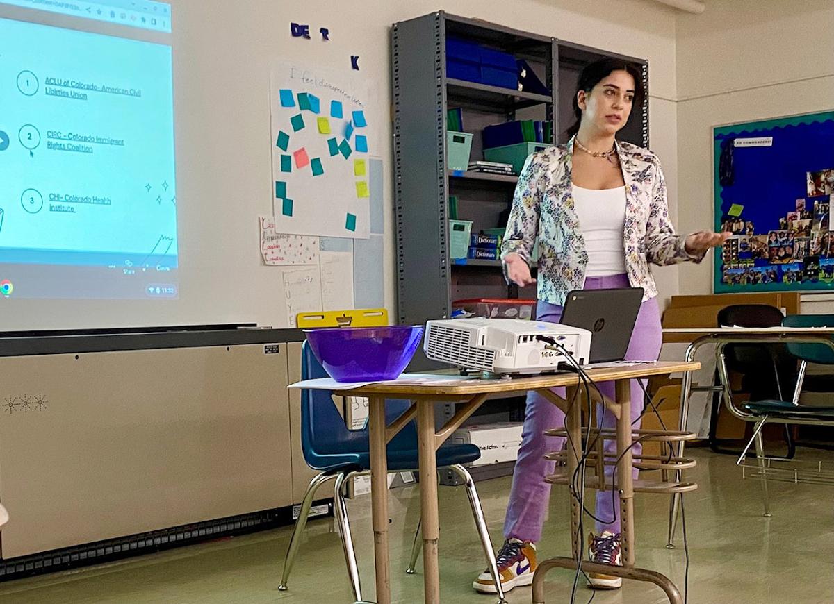Bianey presents slides at the front of a classroom