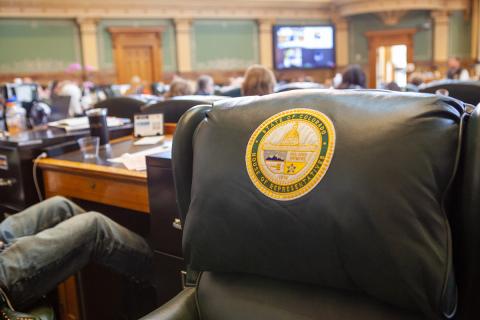 Closeup of a representative's chair with the state logo in the Colorado House.